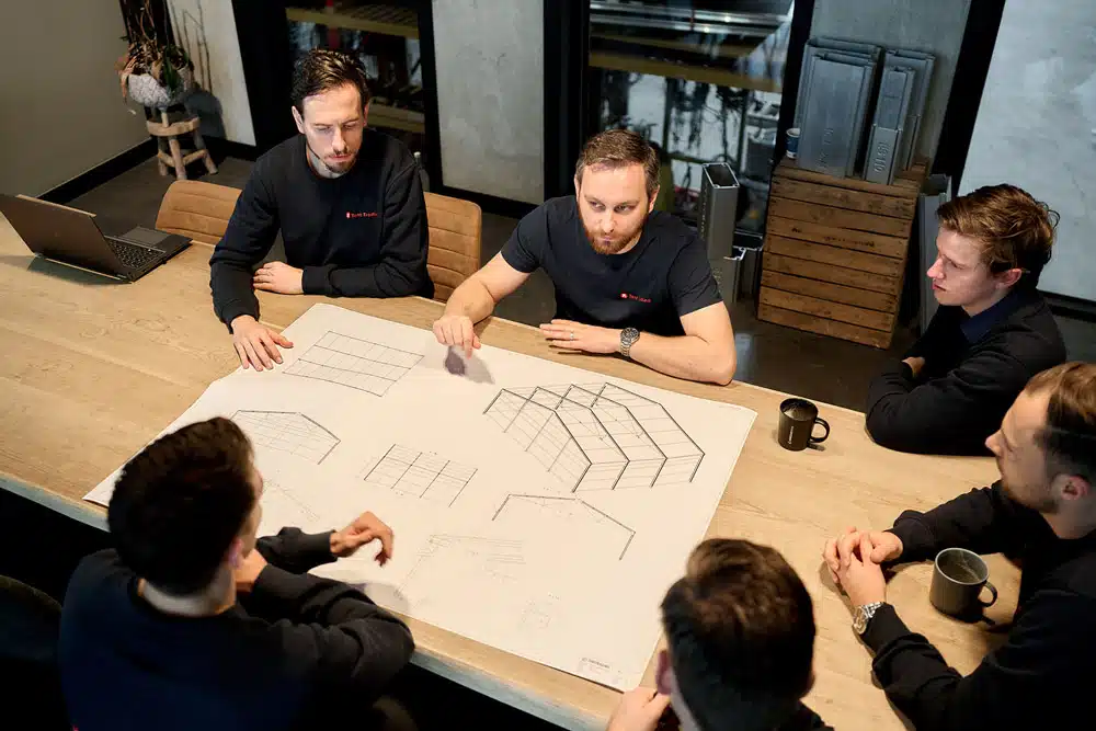 Team engineers bespreekt technische tekeningen van tentconstructie