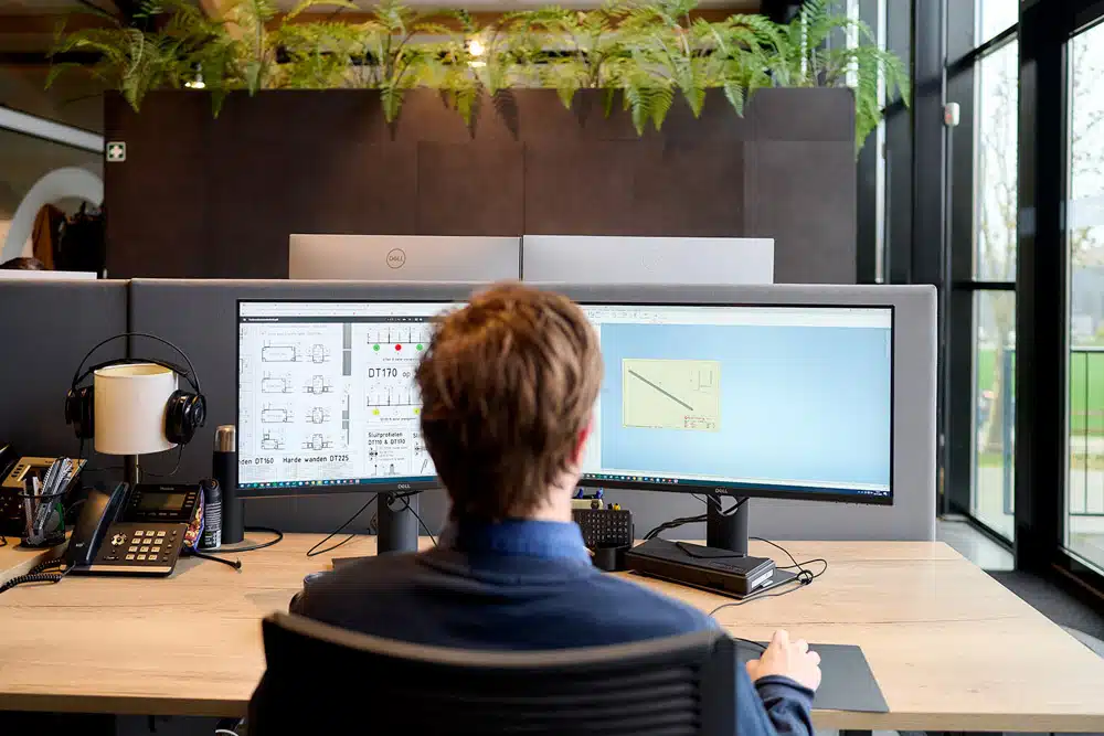 Constructeur bekijkt werktekening van aluminium tentconstructie op scherm