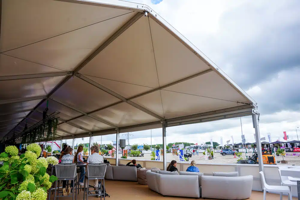 TT160 tent van 15 meter breed ingericht als lounge met zitplaatsen en decoratie.