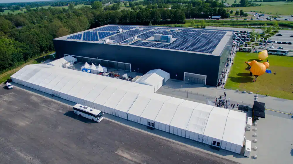 Zeer grote witte tent opgezet naast modern bedrijfspand