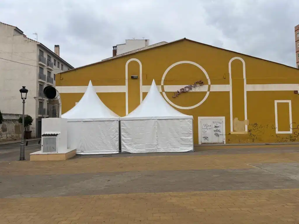 Twee witte pagodetenten met zwaarlastvloeren naast een evenementenlocatie.